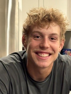 Adam Darveaux, smiling, in a gray T-shirt.